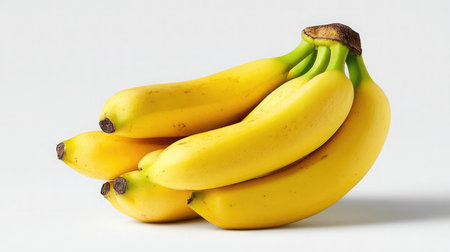 A bunch of bananas with smooth yellow skin placed diagonally on white backdropの素材