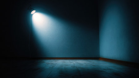 Cool-toned spotlight creating gradient illumination on white wallの素材