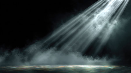 Focused beam of light from a spotlight cutting through theatrical mistの素材