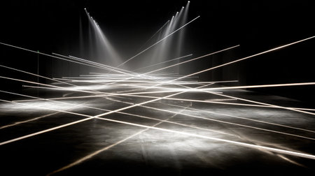 Set of spotlights projecting intersecting beams across black stage floorの素材