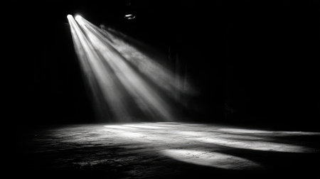 Set of spotlights projecting intersecting beams across black stage floorの素材