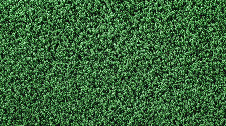 Artificial turf texture in uniform bright green shade creating a sporty backgroundの素材