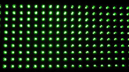 Green LED light pattern glowing against a dark tech-themed backdropの素材