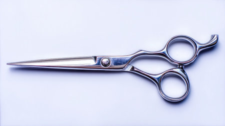 Shiny grooming scissors with thin blade tips in open form, top-down on white backgroundの素材