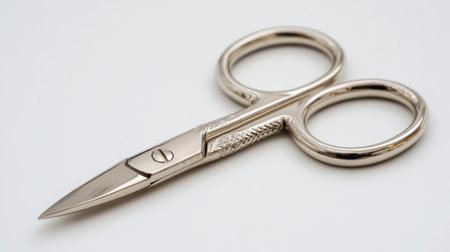 Opened scissors on white background with visible tension screw and polished metalの素材