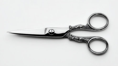 Thin mustache scissors with sharp ends and shiny surface, placed on a bright white backgroundの素材