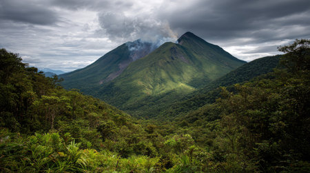 Ancient volcano surrounded by thick jungle with small smoke plume at summitの素材