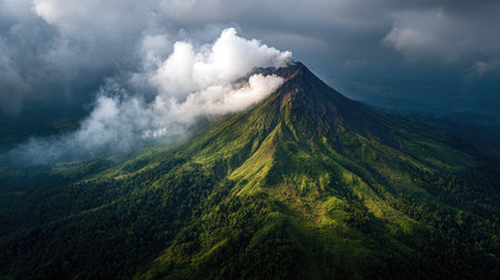 Ancient volcano surrounded by thick jungle with small smoke plume at summitの素材