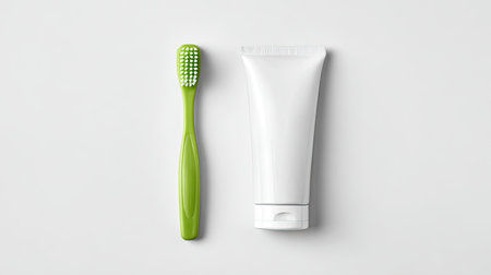 This image features a green toothbrush and a white tube of toothpaste, highlighting essential dental hygiene products. Ideal for health and wellness themes.の素材