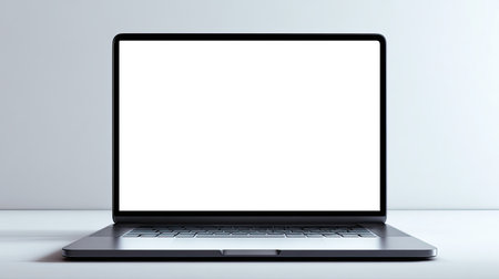 A sleek modern laptop sits on a minimalistic desk with a blank screen. Ideal for showcasing digital content, business presentations, or creative ideas.の素材