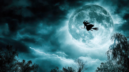 A dark, stormy night with lightning illuminating a silhouette of a witch flying on a broomstick across the full moon.の素材
