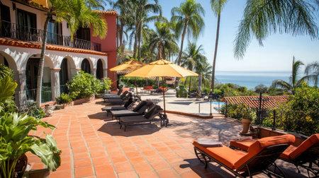 Beachfront hotel terrace with comfortable lounge chairs and umbrellas, offering a perfect spot to relax and enjoy the ocean view.の素材