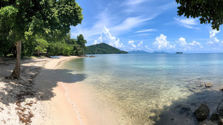 Experience the calm beauty of a tropical beach featuring crystal-clear water, soft sand, vibrant trees, and scenic islands under a bright blue sky. A perfect escape.の素材