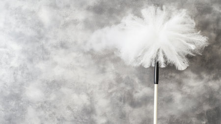 This image showcases a fluffy feather duster against a textured gray background, ideal for promoting cleaning tools and home maintenance products. Perfect for interior design themes.の素材