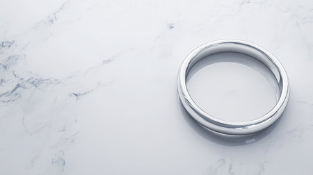 A sleek and elegant silver ring rests on a smooth marble surface, symbolizing love and commitment. This minimalist design is perfect for wedding and engagement photography.の素材