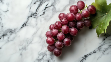 A cluster of fresh red grapes elegantly arranged on a marble surface, showcasing their vibrant color and natural beauty, perfect for culinary uses.の素材