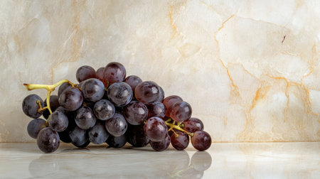 A stunning arrangement of fresh dark grapes resting on a smooth marble surface. This image highlights the beauty and freshness of natural fruit, ideal for food-related projects.の素材