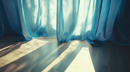 Discover the serene beauty of soft light streaming through sheer blue curtains, creating gentle shadows on the floor and a warm, tranquil atmosphere.の素材