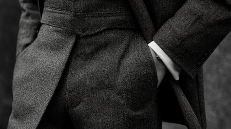 This elegant detail of a tailored suit features hands casually tucked in pockets, highlighting the sophistication and luxury of men's fashion in a modern, minimalist style.の素材