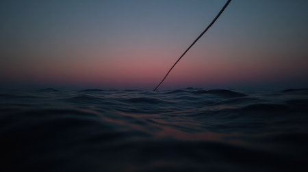 A serene seascape at dusk captures gentle waves under a beautifully colored sky, featuring a long line extending towards the horizon, evoking tranquility and contemplation.の素材