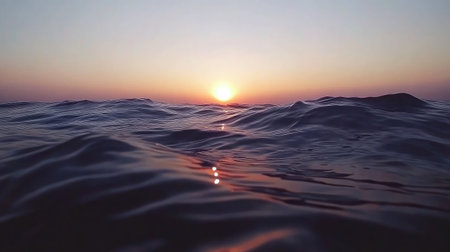 Experience the calming beauty of ocean waves splashing gently under a vibrant sunset sky, where reflections dance on the waterの素材