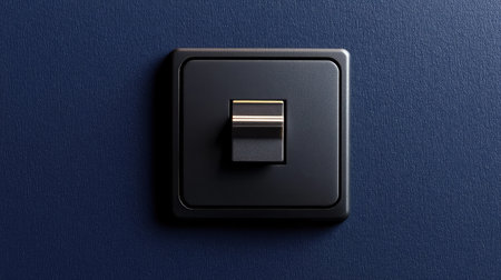 A sleek black light switch set against a rich dark blue wall, highlighting modern design principles, perfect for stylish interior decor and creating a chic ambiance in any living space.の素材