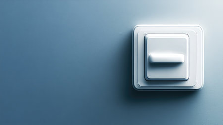 A sleek modern light switch mounted on a softly lit blue wall, showcasing a blend of contemporary design and functionality perfect for various interior settings.の素材