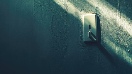 A minimalist wall switch captures soft light and shadows, enhancing the textured surface. The image conveys a calm ambiance, perfect for interior design inspiration.の素材