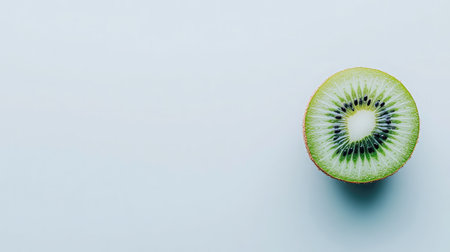 This stunning image features a fresh organic kiwi fruit halved, revealing its vibrant green flesh and black seeds, perfect for healthy dishes, snacks, and culinary inspiration.の素材