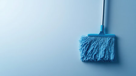 A single blue mop against a soft light background, ideal for emphasizing cleanliness and modern household tools in cleaning and maintenance themes.の素材