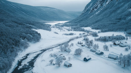 Wide shot of a snowy village in a low valley, with a frozen river winding through the homesの素材