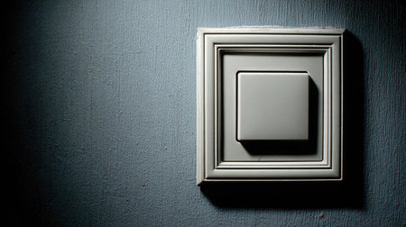This image features a close-up of a light switch against a textured wall, showcasing a modern design with soft shadows in a dimly lit ambiance, perfect for decor inspiration.の素材
