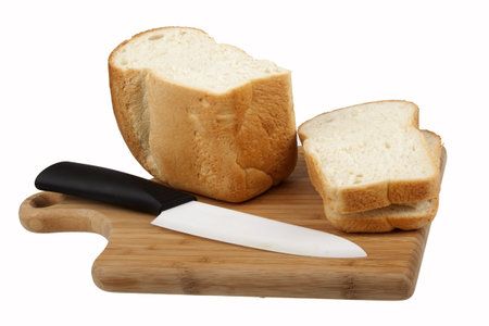White bread and knife on kitchen board on white background