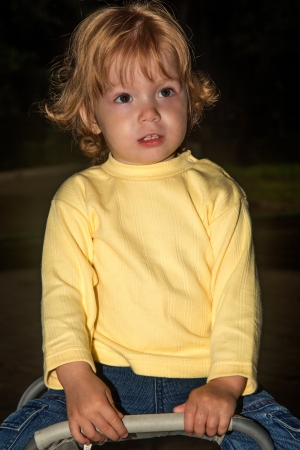 The little girl sits on chair in parkの写真素材
