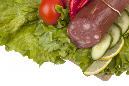 Sausage with vegetables on  kitchen board on white backgroundの写真素材