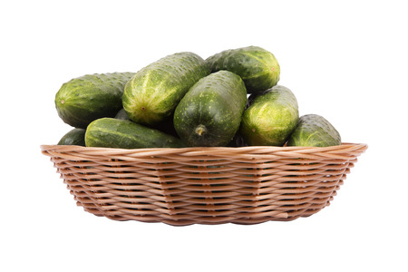 Brown basket with ripe green cucumbers isolated on white backgroundの写真素材
