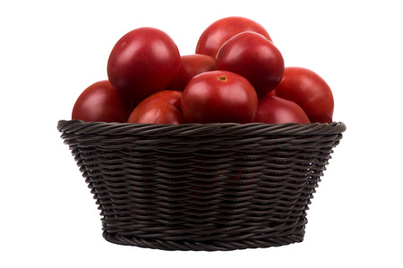 Brown wattled basket with red ripe tomatoes isolated on white backgroundの写真素材