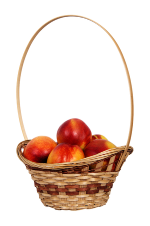 Nectarines fruit in basket isolated on white backgroundの写真素材