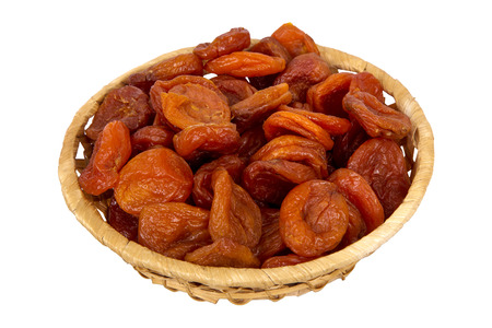 Wattled basket with dried apricots isolated on white backgroundの写真素材