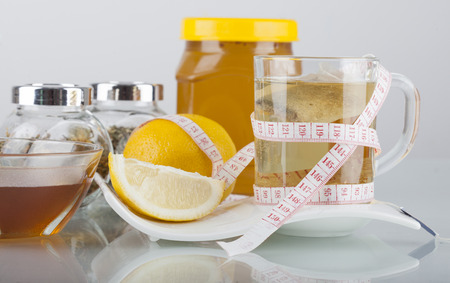 Tea in cup with honey and lemon on a white backgroundの写真素材