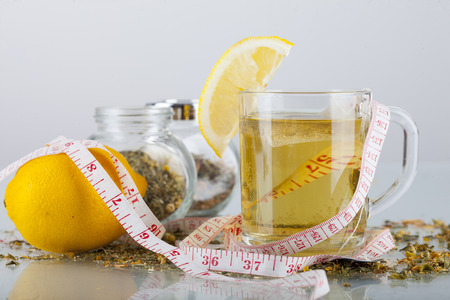 Tea in cup with honey and lemon on a white backgroundの写真素材