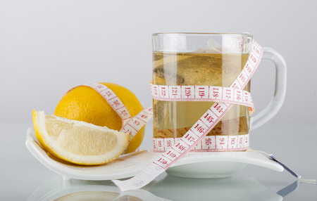 Tea in cup with honey and lemon on a white backgroundの写真素材