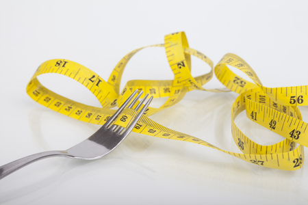 Dieting concept with fork and meterの写真素材