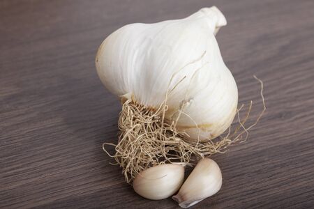 raw garlic on a wooden plankの写真素材