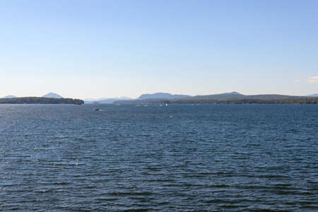 View of the coast of the lake with mountains in the background.の写真素材