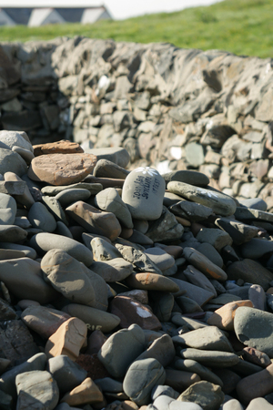 Pile of small pebbles with names of loved ones in a churchyard in Scotlandの写真素材