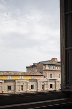 Rooftop view on a cloudy day in Rome, ITaly, showing shabby painted buildings with tiled roofsの写真素材
