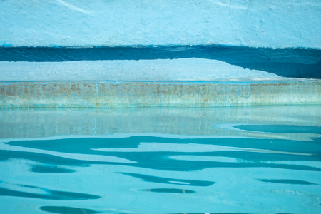 Detail of water rippling in blue swimming pool and reflections on the sideの写真素材