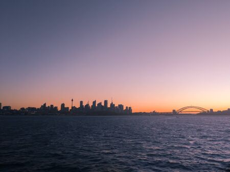 Silhouetted view of Sydney Harbour skyline at sunset, Australiaの写真素材