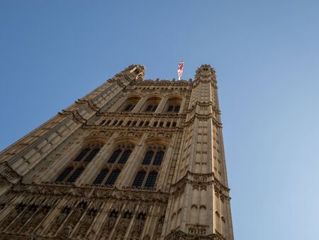 LONDON, UK - SEPTEMBER 20 2019: Union Jack flag flying over the looming Houses of Parliament against a blue sky, Westminster, Londonのeditorial素材